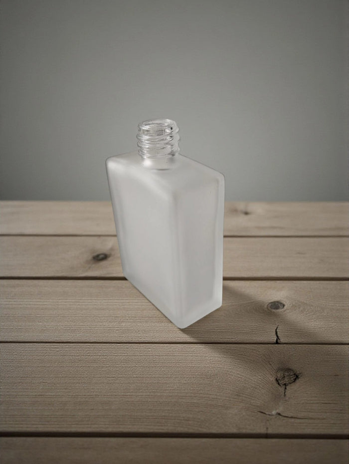 Clear glass bottle on a wooden surface with a gray background