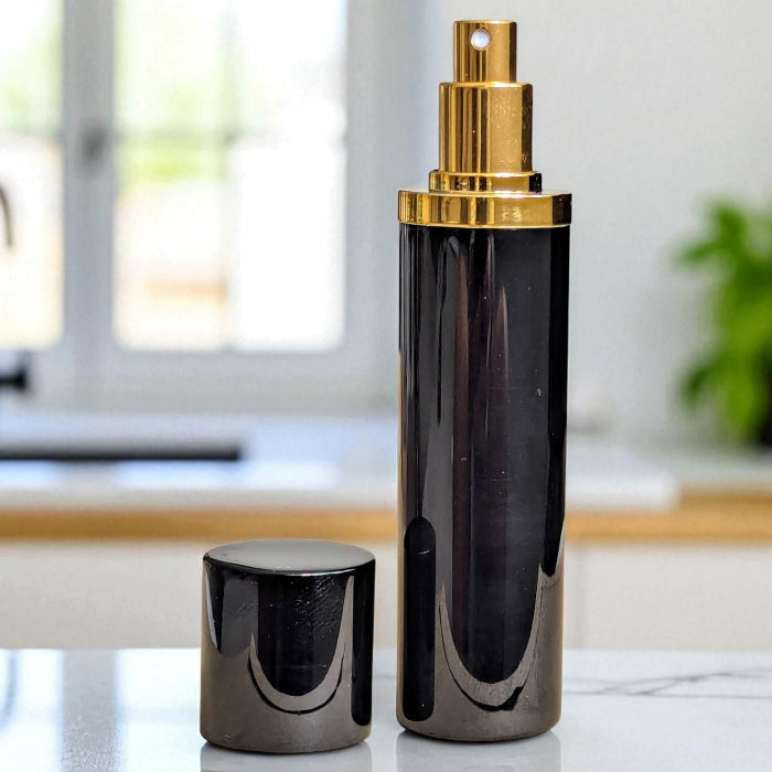  black and gold 10ml perfume atomizer with lid off on marble surface