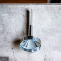 small metal funnel with plastic extension on marble top