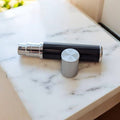 5ml luxury easy fill black and silver perfume atomizer called the vapora by the essential atomizer company on marble surface with lid off