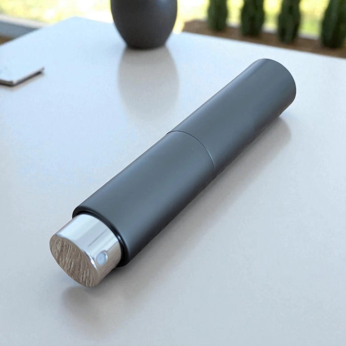 essential atomizer sleek grey twist up 8ml perfume atomizer layed on flat surface