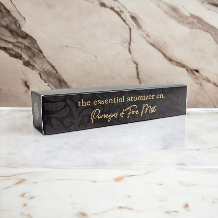 essential atomizer company box on marble surface